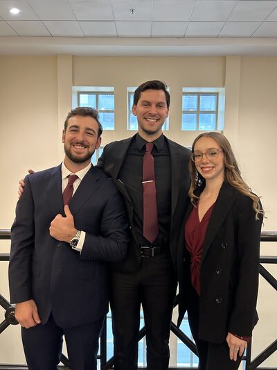 Three team members smiling together at a company event